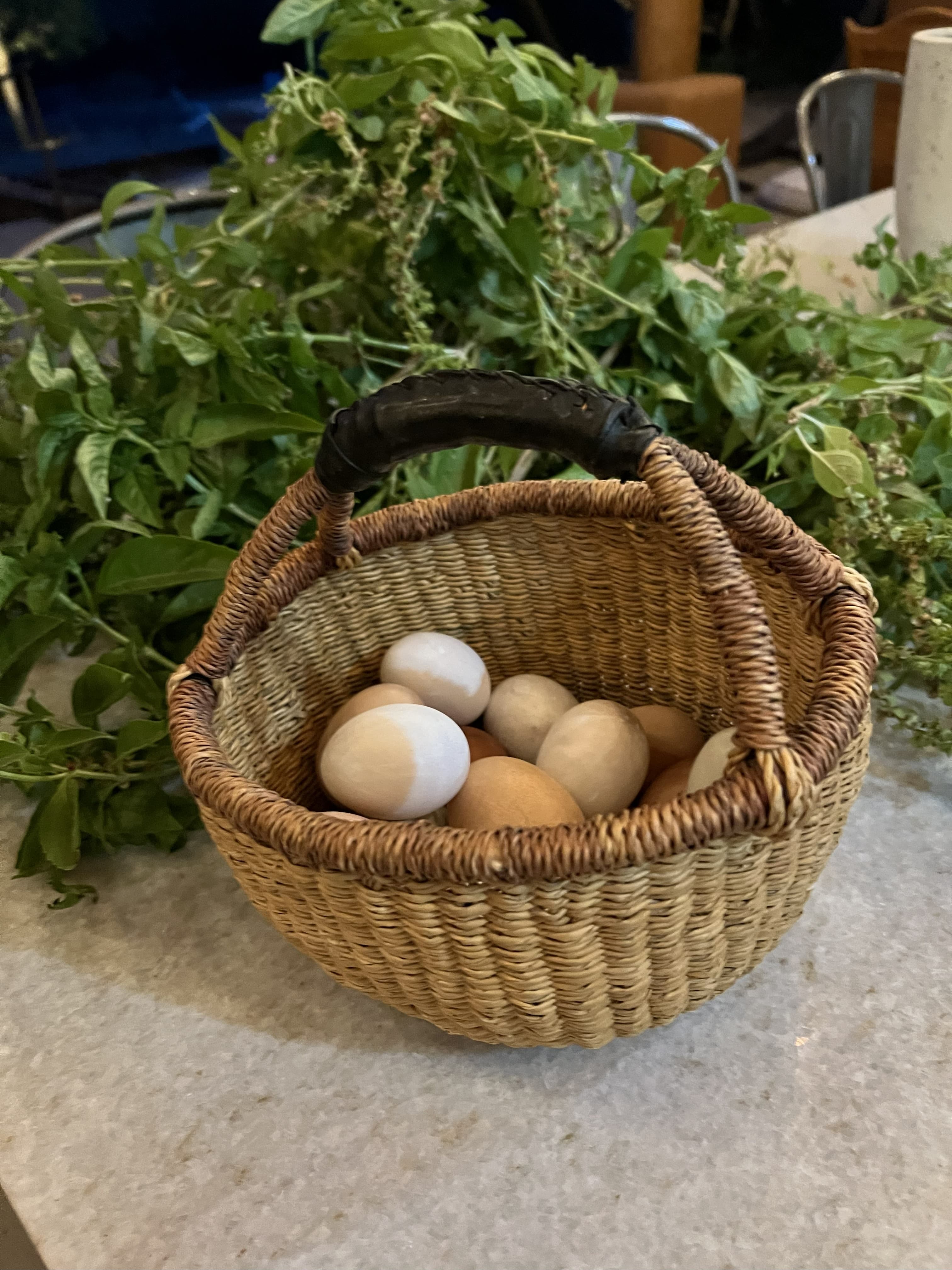 Basket of farm-fresh eggs nestled in a spread of garden herbs